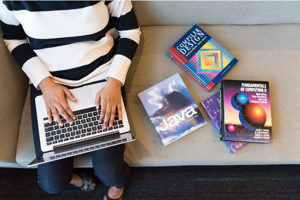 An individual conducting a cost analysis of Coveo vs BA Insight on the laptop